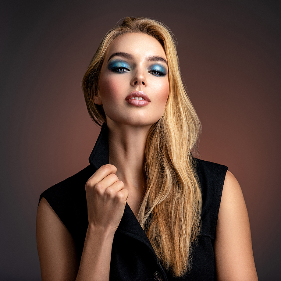 Photo of young stylish woman in black clothes with blue make-u